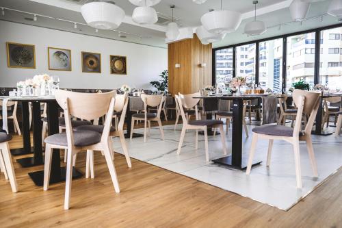 a restaurant with tables and chairs and windows at Poeme Mamaia Retreat in Mamaia