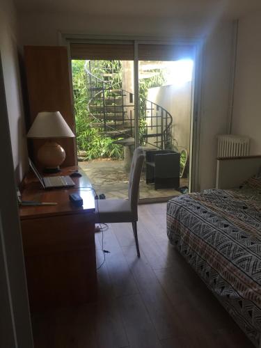 - une chambre avec un bureau, un lit et une fenêtre dans l'établissement Maison Hautes Bruyères, à Cachan