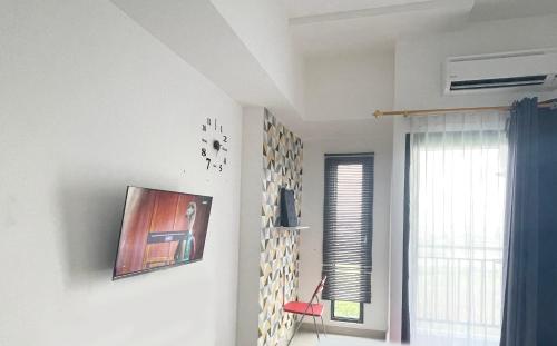 a living room with a picture on the wall at Apartemen Sayana Harapan Indah by Cheapinn in Tambun-lobangbuaja