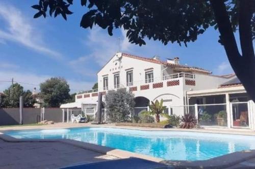 une maison avec une piscine devant une maison dans l'établissement La Cigale Argeles Albères, à Plage dʼArgelès