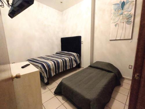 a small room with a bed and a ottoman at Departamento amplio con estacionamiento, WiFi rápido, equipado, muy cerca de Catedral in Zacatecas