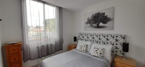 une chambre avec un lit et une grande fenêtre dans l'établissement La Cigale Argeles Albères, à Plage dʼArgelès