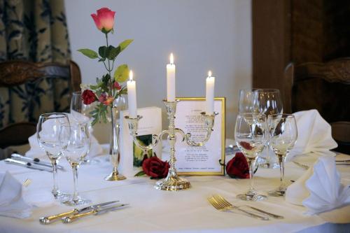 einen Tisch mit Weingläsern und Kerzen darauf in der Unterkunft Hotel-Spa & Restaurant Logis Domaine Langmatt in Murbach