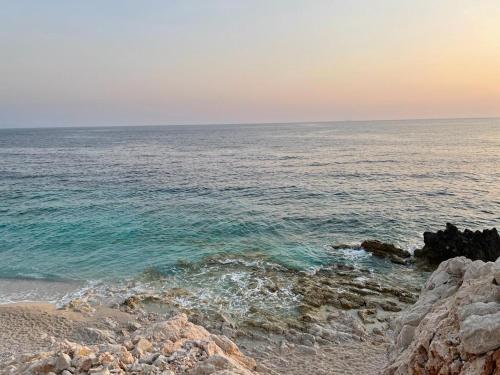 a view of the ocean from a rocky beach at Palermiti Luxury Rooms in Himare
