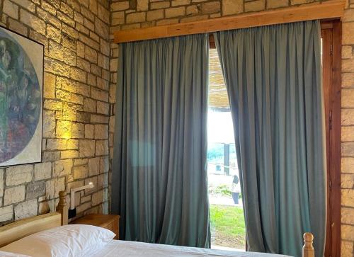 a bedroom with a bed and a large window at Palermiti Luxury Rooms in Himare