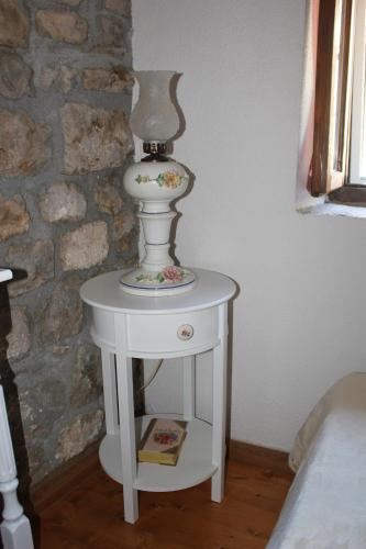 a white end table with a vase on top of it at Stone house Castellum in Kaštela