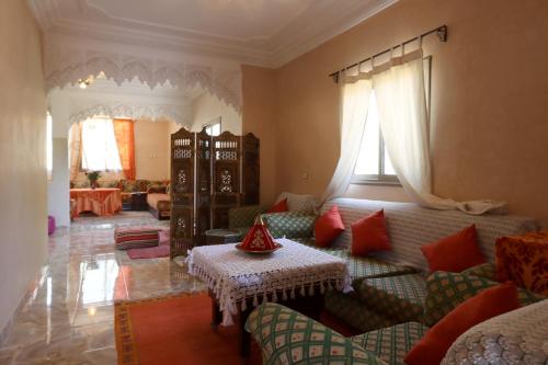 ein Wohnzimmer mit einem Sofa und einem Tisch in der Unterkunft villa saada in Marrakesch