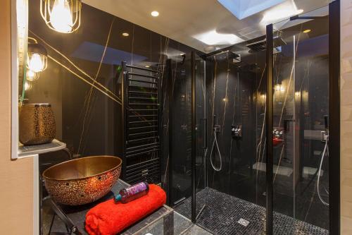 uma casa de banho com um chuveiro com uma tigela e uma banheira em Loft Room 85, petite maison avec jacuzzi privatif em Les Sables-dʼOlonne