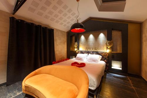 um quarto com uma cama e uma cadeira em Loft Room 85, petite maison avec jacuzzi privatif em Les Sables-dʼOlonne