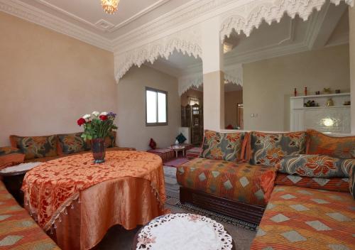 a living room with couches and a table with flowers on it at villa saada in Marrakech