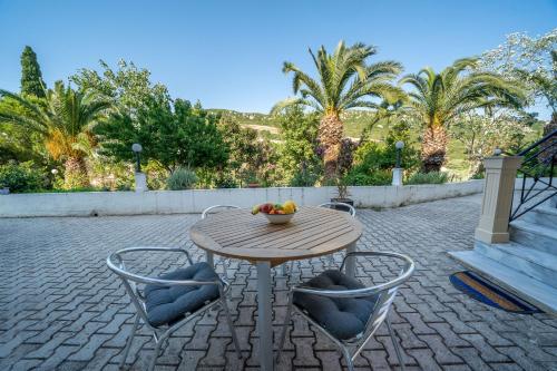 a wooden table and chairs with a bowl of fruit on it at Iris Apartments in Minia