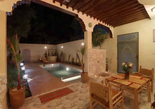 a patio with a table and a swimming pool at villa saada in Marrakech