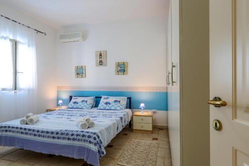 a bedroom with a blue and white bed and a window at Appartamento Casa dell'Olivo in Marina di Pescoluse