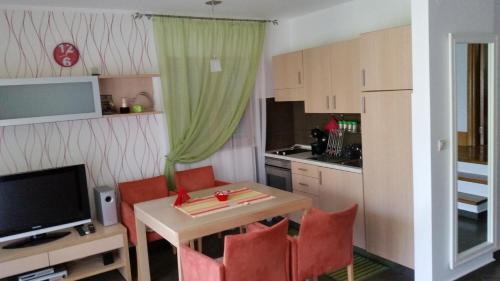 a small kitchen with a table and chairs and a television at Apartments Radulovic in Kotor