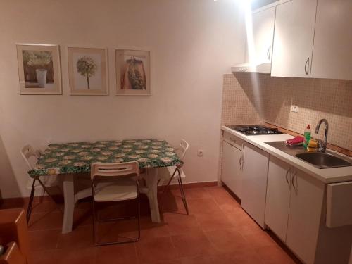 a small kitchen with a table and a sink at Apartman Maja in Međugorje