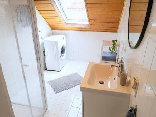 a small bathroom with a sink and a shower at Family-Apartment mit Balkon, Küche, Parkplatz & Waschmaschine in Offenburg