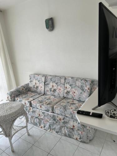 a living room with a couch with flowers on it at Home2Home Guesthouse in Christ Church