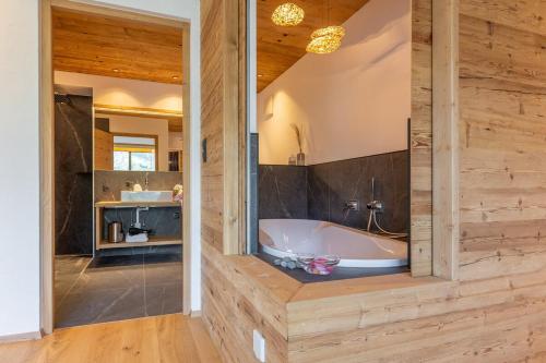 een badkamer met een bad en een wastafel bij Apartment Himmelreichhof in San Candido