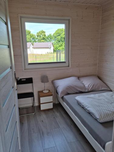 a bedroom with a bed and a window at Kalimera in Kołczewo