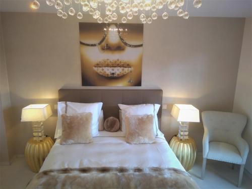 um quarto com uma cama com um retrato de uma mulher em B&B Maison Durbois em Durbuy