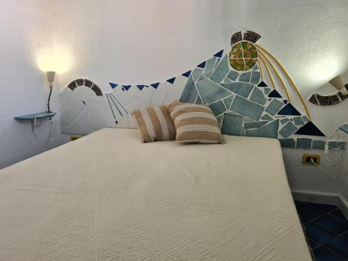 sypialnia z dużym łóżkiem i mozaikową ścianą w obiekcie terrazzo al Mare w mieście Terrasini