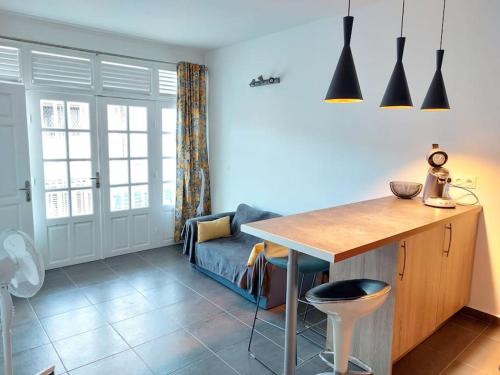 una cucina con tavolo e divano in una camera di Charmant pied-à-terre coeur de ville a Pointe-à-Pitre