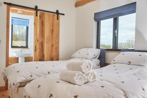 two beds in a room with two windows at Waters Edge Retreat in Naseby