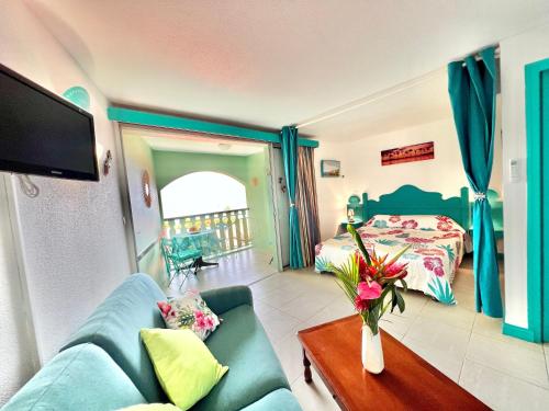 a living room with a couch and a bed at Les Hauts De Caritan in Sainte-Anne