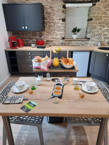 una mesa de madera con comida en la cocina en Les étangs du moulin d'Harcy, en Lonny