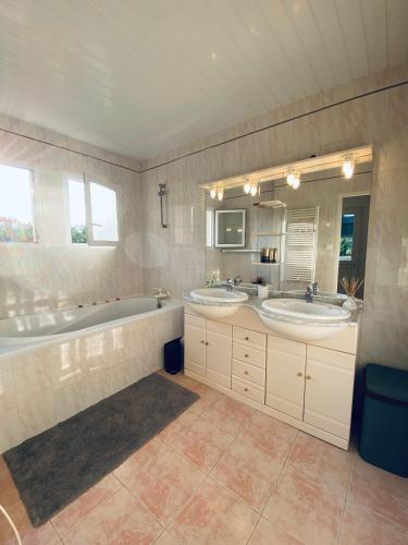 La grande salle de bains est pourvue de 2 lavabos et d'une baignoire. dans l'établissement Maison en pierre à la campagne en Périgord Dordogne, à Saint-Germain-du-Salembre