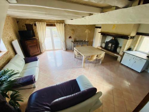 un salon avec un canapé et une table dans l'établissement Maison en pierre à la campagne en Périgord Dordogne, à Saint-Germain-du-Salembre