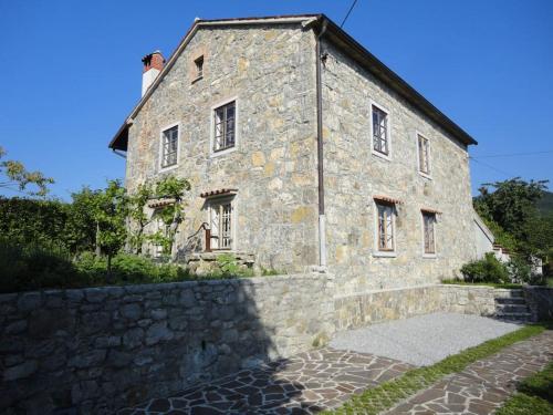 un antiguo edificio de piedra con una pared de piedra en A lovely house in Vipava valley en Vipava