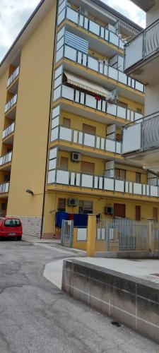 um prédio de apartamentos com um carro vermelho estacionado em frente em APPARTAMENTO IN SOTTOMARINA DI CHIOGGIA em Chioggia