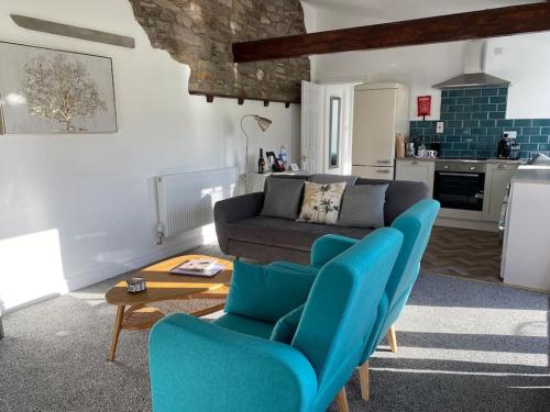 sala de estar con sillas azules y sofá en South Cottage - Garden, Views, Parking, Dogs, Cheshire, Walks, Family en Adlington