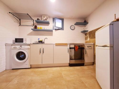 eine Küche mit einem Kühlschrank und einer Waschmaschine in der Unterkunft A aira da xoaniña in Allariz