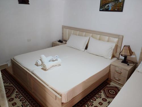a bedroom with a bed with two towels on it at Tomor Shehu Guest House in Berat