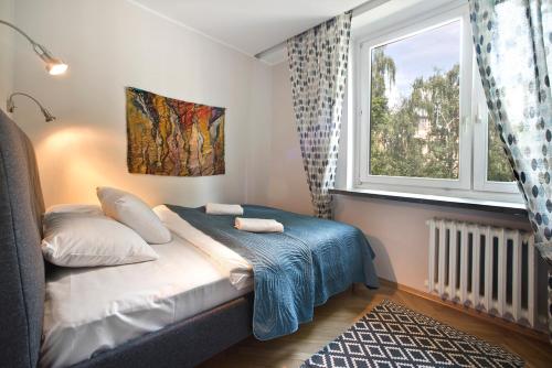 1 dormitorio con 1 cama con ventana y alfombra en P&O Apartments Bielańska, en Varsovia