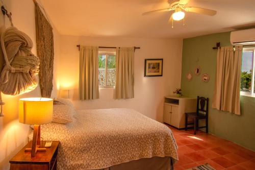 une chambre avec un lit et un ventilateur de plafond dans l'établissement Budgies, à Cozumel