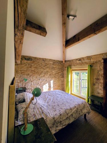 une chambre avec un lit et une lampe sur une table dans l'établissement La Première Vigne, à Puycelci