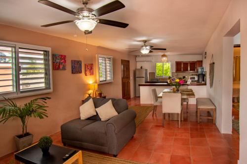 a living room with a couch and a kitchen at Budgies in Cozumel