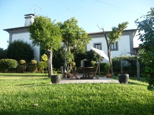 a white house with a garden and a table at Casa de São Braz in Landim