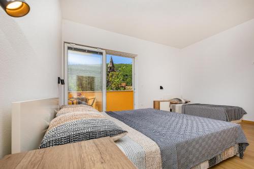 una camera con due letti e una grande finestra di Olive tree apartment 1 a Prijevor