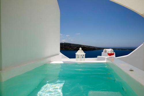 a pool in a house with a view of the water at Marizan Caves & Villas in Oia