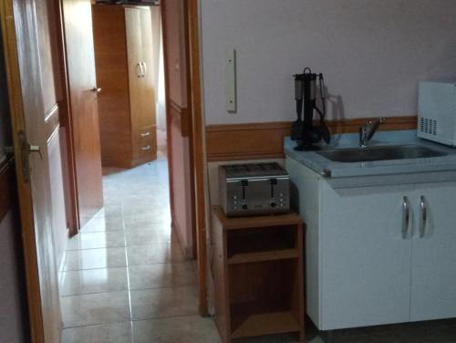 a kitchen with a sink and a stove at Departamentos Paisaje del Beagle in Ushuaia