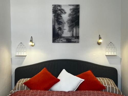 a bed with orange and white pillows on it at Prater Tree Apartment near city centre in Vienna