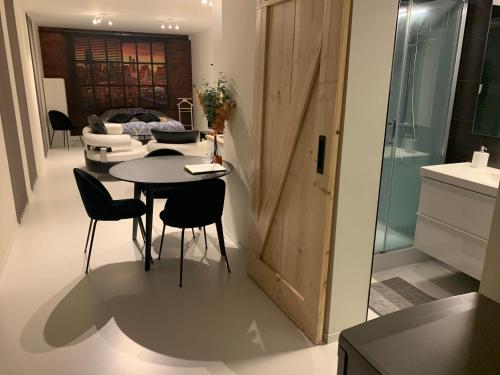 een keuken en een woonkamer met een tafel en stoelen bij Prachtige gastsuite in Ranst "Studio 34" in Ranst