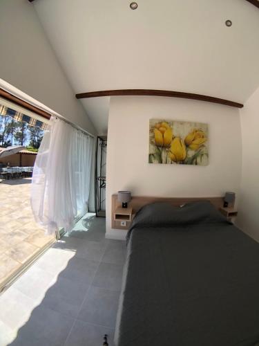 une chambre avec un lit avec un tableau sur le mur dans l'établissement Grande Villa 4 étoiles 20pax entre Cannes and Saint Tropez, à Puget-sur Argens