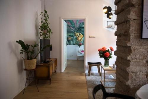 a living room with a hallway with a door with a plant at Pink Rabbit Apart in Gdańsk