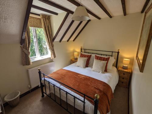 a bedroom with a bed and a window at Butchers Cottage in Ironbridge