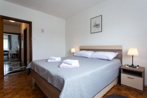 1 dormitorio con 1 cama con sábanas y almohadas blancas en House Vranić, en Rakovica